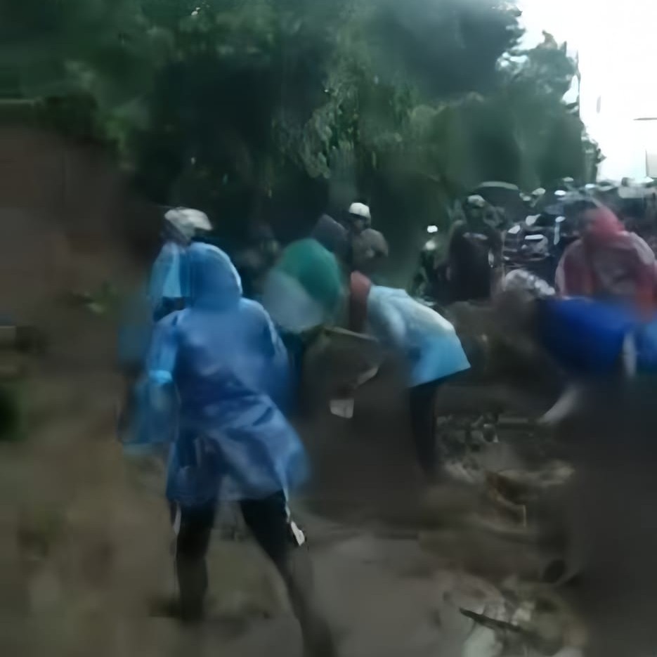 Warga mengenakan jas hujan bergotong royong membersihkan lumpur dan kayu agar akses kembali terbuka. Dok. warga